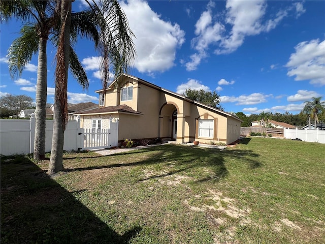 rear view of property featuring a lawn