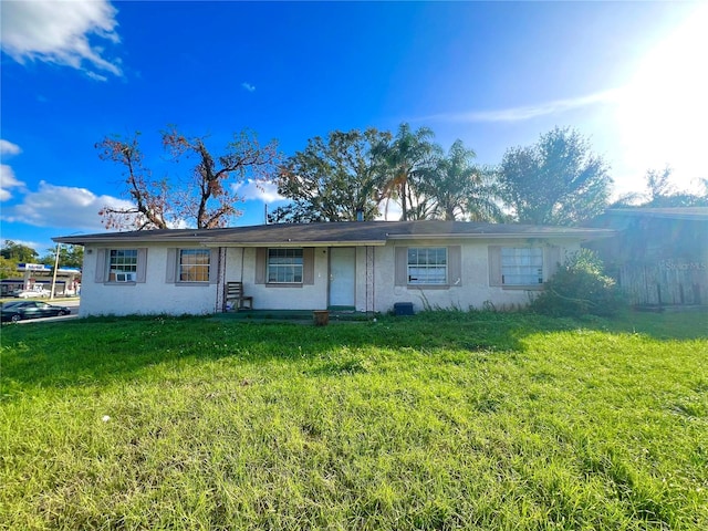 ranch-style home with a front yard and cooling unit