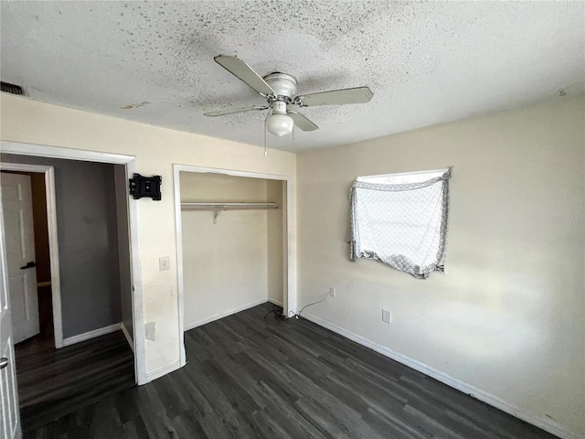 unfurnished bedroom featuring ceiling fan, dark hardwood / wood-style floors, a textured ceiling, and a closet