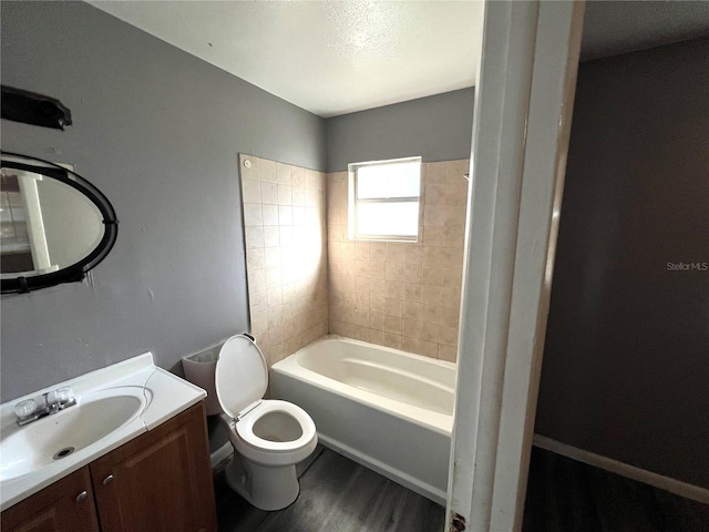 full bathroom with hardwood / wood-style floors, vanity, toilet, and tiled shower / bath combo