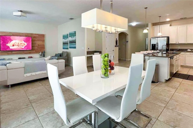 tiled dining room with an inviting chandelier and sink