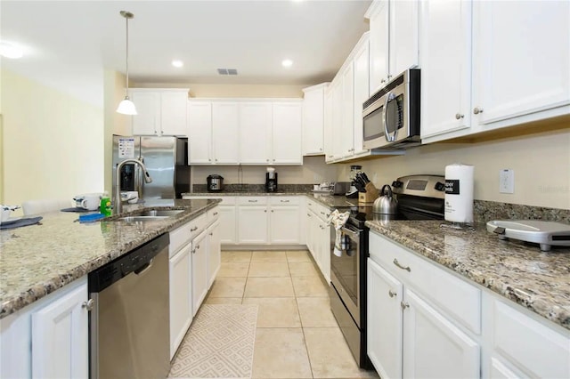 kitchen featuring pendant lighting, sink, light tile patterned flooring, white cabinetry, and stainless steel appliances