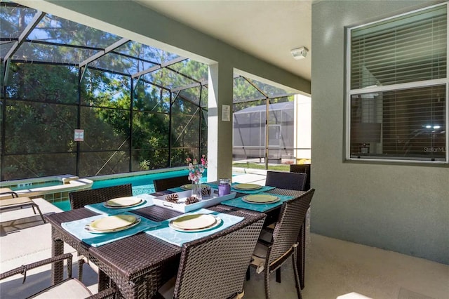 view of patio / terrace with a swimming pool with hot tub and glass enclosure