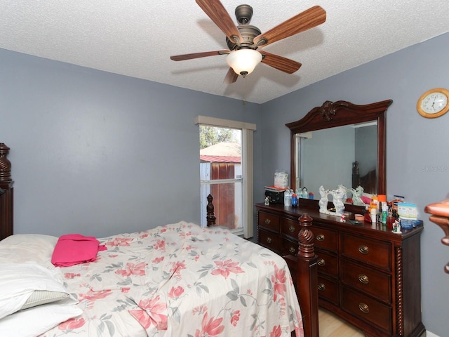 bedroom with ceiling fan and a textured ceiling