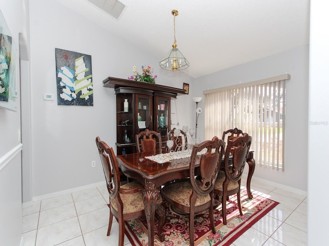 552 Eagle Ct, Poinciana, FL 34759 - dining area with lofted ceiling, light tile patterned flooring, and baseboards