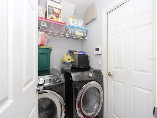 clothes washing area with a textured ceiling and washing machine and clothes dryer