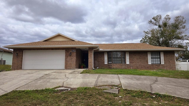 ranch-style house featuring central AC and a garage