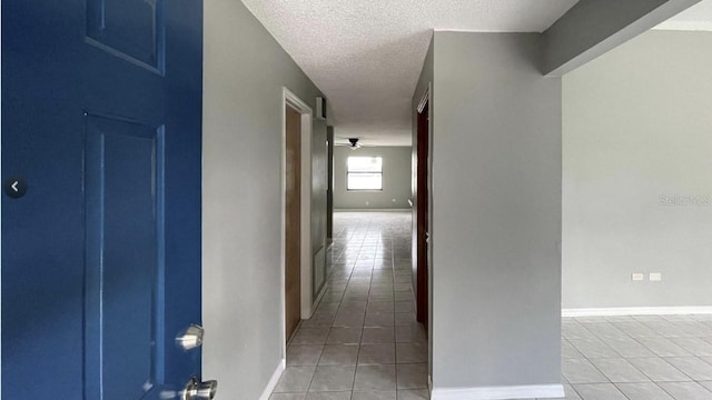 hall with light tile patterned floors and a textured ceiling