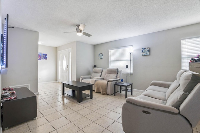 living room featuring a wealth of natural light, a textured ceiling, ceiling fan, and light tile patterned flooring