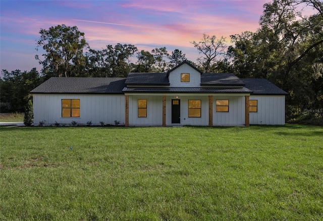 modern farmhouse style home with a lawn and a porch