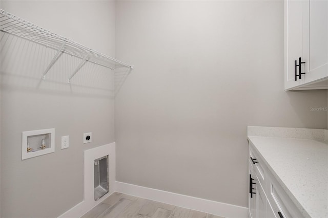 washroom with electric dryer hookup, cabinets, washer hookup, and light hardwood / wood-style floors