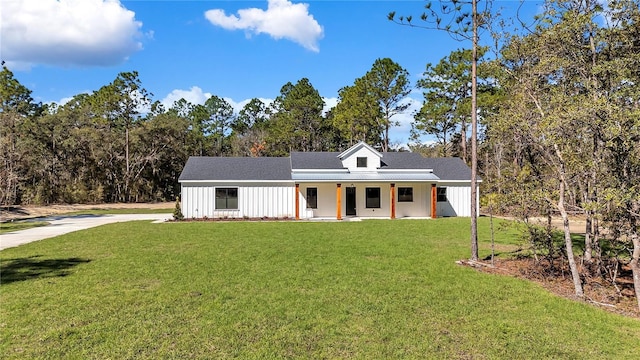 modern farmhouse style home featuring a porch, board and batten siding, and a front lawn