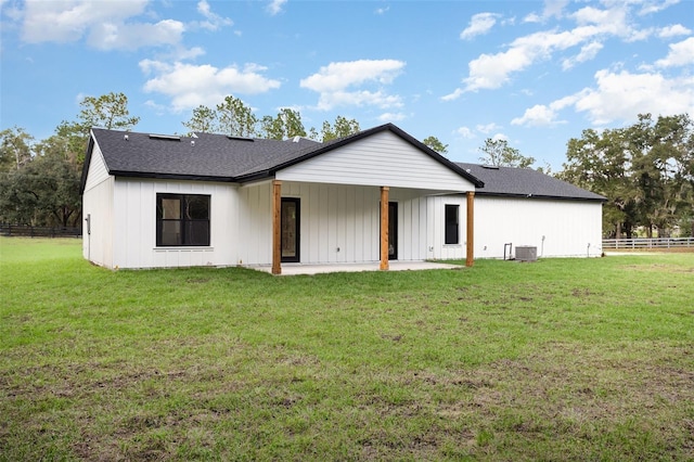 back of house featuring cooling unit, a patio area, and a lawn