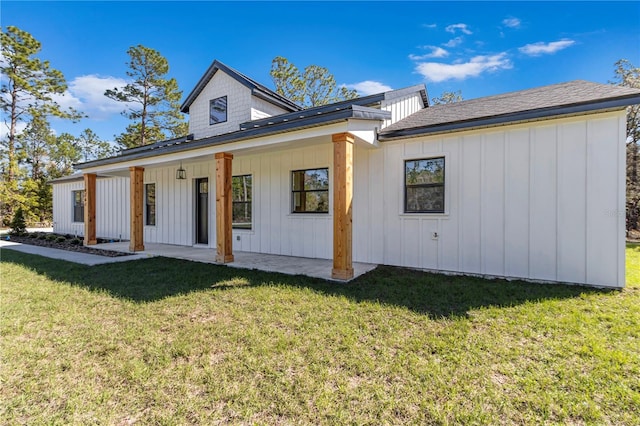 back of house featuring a lawn and board and batten siding