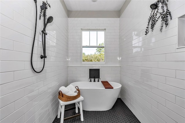 full bathroom featuring a freestanding tub, tile patterned flooring, and tile walls