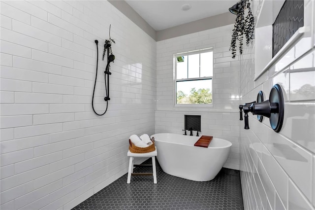 bathroom with a freestanding tub, a tile shower, and tile walls