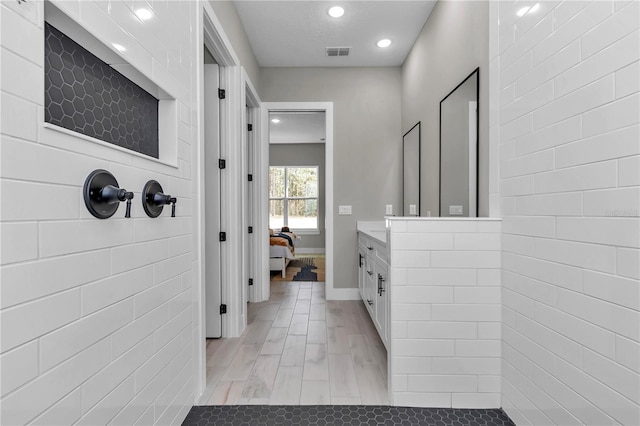 full bath featuring recessed lighting, visible vents, connected bathroom, vanity, and baseboards