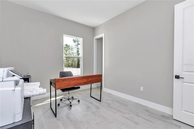 home office featuring light wood finished floors, independent washer and dryer, and baseboards