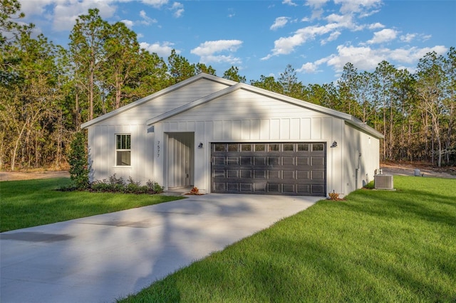 view of front of property featuring cooling unit, a front lawn, and a garage