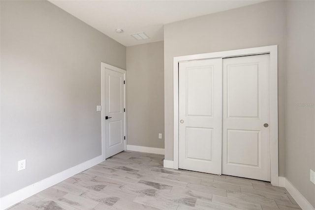 unfurnished bedroom featuring light hardwood / wood-style flooring and a closet