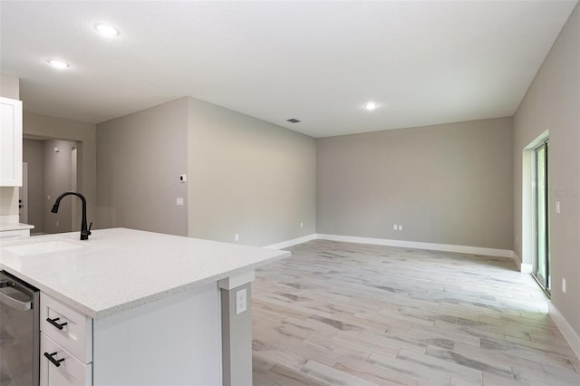 kitchen with sink, a center island with sink, light hardwood / wood-style flooring, dishwasher, and white cabinets