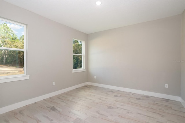 empty room with light hardwood / wood-style flooring and a wealth of natural light