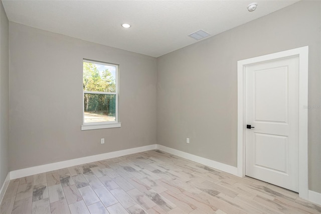 unfurnished room featuring light hardwood / wood-style flooring and a textured ceiling