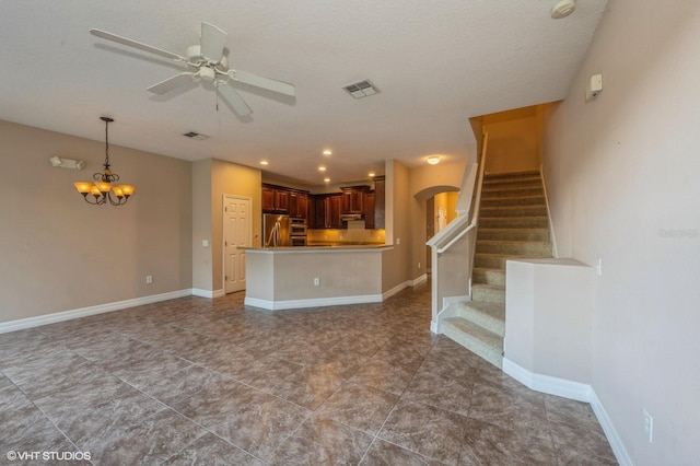 unfurnished living room featuring a textured ceiling and ceiling fan with notable chandelier