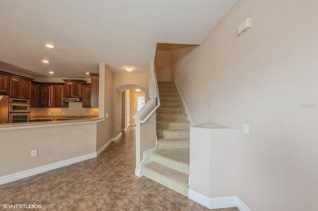 stairs with a textured ceiling and tile patterned floors