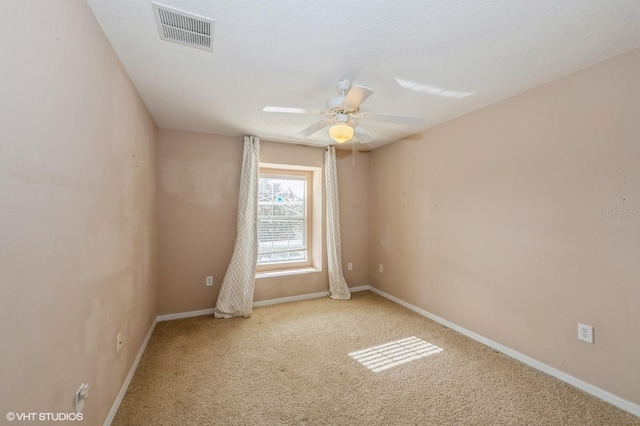 spare room with ceiling fan and light carpet