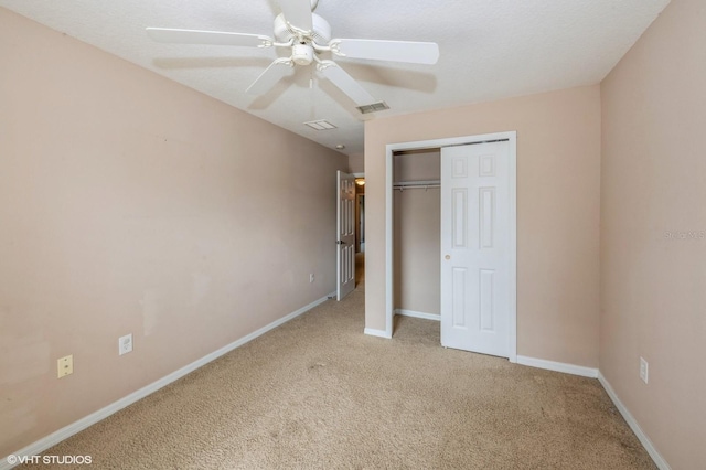 unfurnished bedroom featuring ceiling fan, a closet, and light carpet