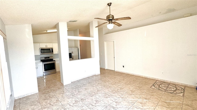 interior space featuring lofted ceiling, ceiling fan, and a textured ceiling