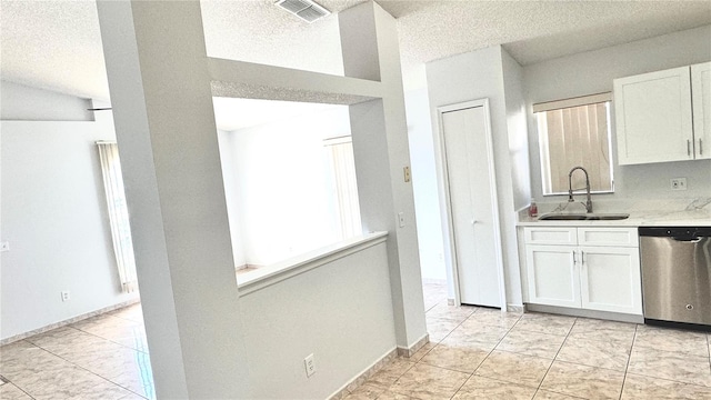 kitchen with white cabinetry, dishwasher, sink, and a textured ceiling