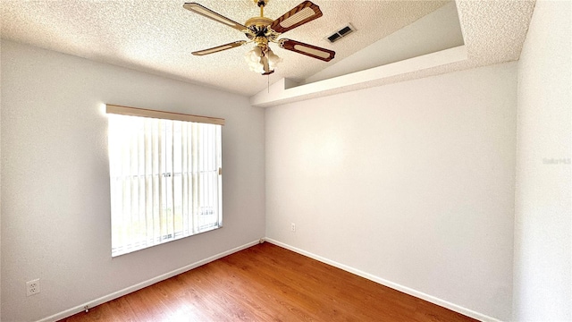 empty room featuring hardwood / wood-style floors, a textured ceiling, vaulted ceiling, and ceiling fan