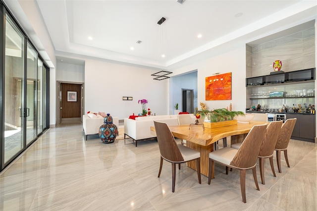 dining room with a tray ceiling and bar