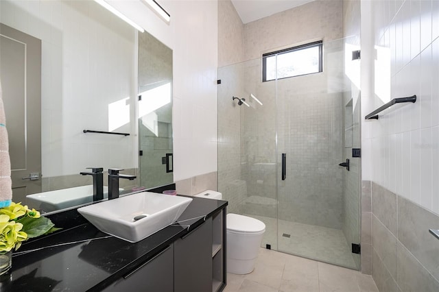 bathroom featuring tile patterned floors, vanity, a shower with shower door, and toilet