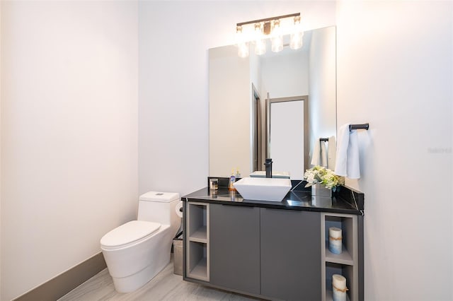 bathroom with hardwood / wood-style floors, vanity, and toilet