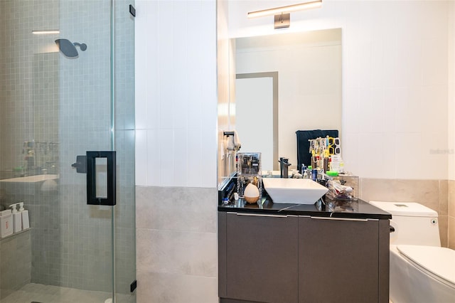 bathroom with toilet, vanity, tile walls, and walk in shower