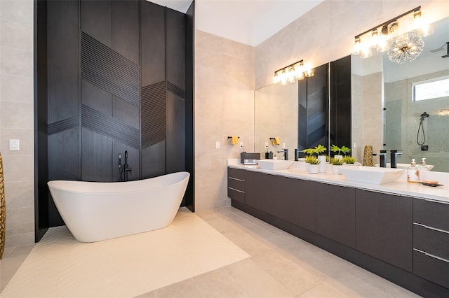 bathroom with tile patterned flooring, vanity, tile walls, and independent shower and bath