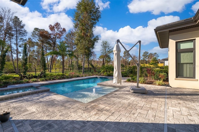 view of swimming pool featuring a patio area and an in ground hot tub