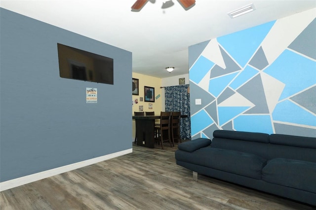 living room with wood-type flooring and ceiling fan