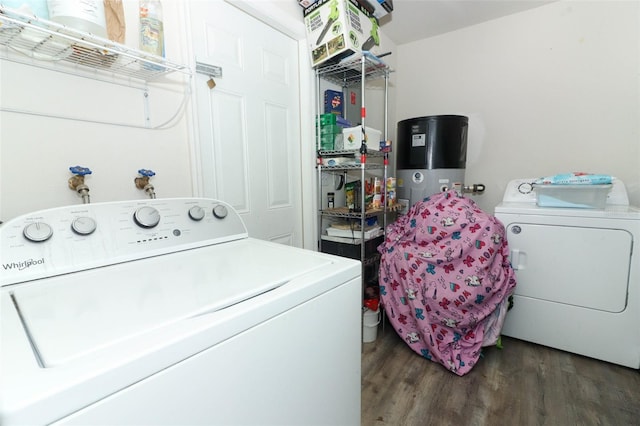 laundry area with washing machine and clothes dryer, dark hardwood / wood-style floors, and water heater