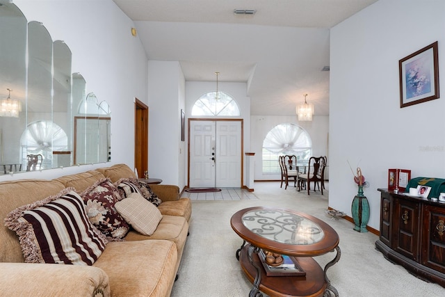 living room with light colored carpet, lofted ceiling, and an inviting chandelier