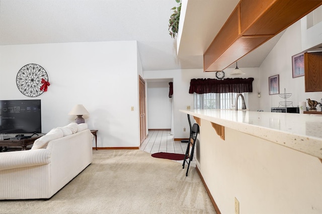 living room with sink, light colored carpet, and vaulted ceiling