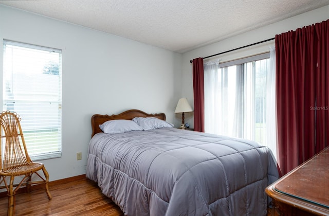 bedroom featuring hardwood / wood-style floors and a textured ceiling