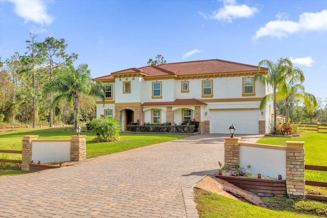 mediterranean / spanish-style home with a front lawn and a garage