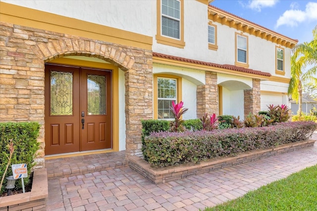 view of exterior entry featuring a garage and french doors