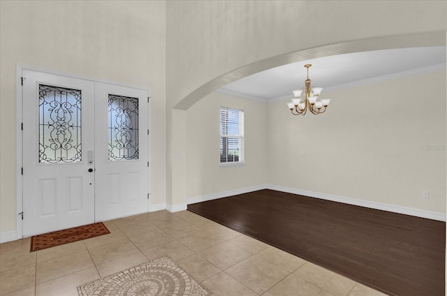 19206 Robertson St, Orlando, FL 32833 - entrance foyer featuring a chandelier, arched walkways, tile patterned floors, and ornamental molding