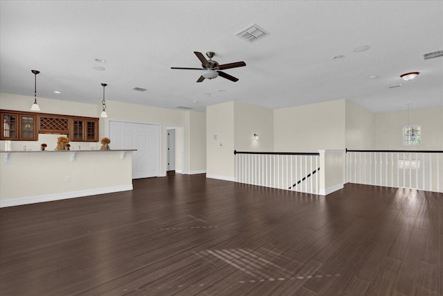 unfurnished living room featuring ceiling fan and dark hardwood / wood-style floors