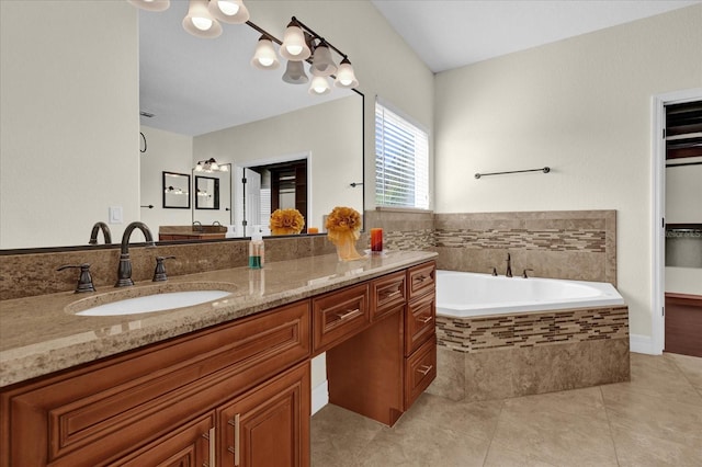 bathroom with tile patterned floors, vanity, and tiled bath